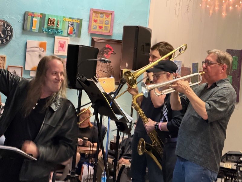 Ryan Evans singing beside the horn line: Cooper Tyson on trombone, John Anderson on saxophone, Dave Selley on trumpet